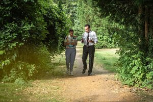 Therapeuten-Patienten-Gespräch Mann und Frau spazieren auf einem Waldweg nebeneinander her und unterhalten sich.